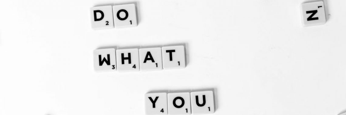 Scrabble tiles spelling 'Do What You Love' on a white background, encouraging creativity.